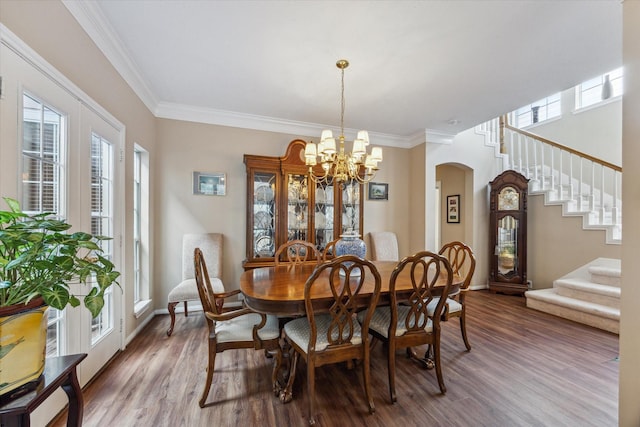 dining space with a chandelier, hardwood / wood-style floors, and ornamental molding