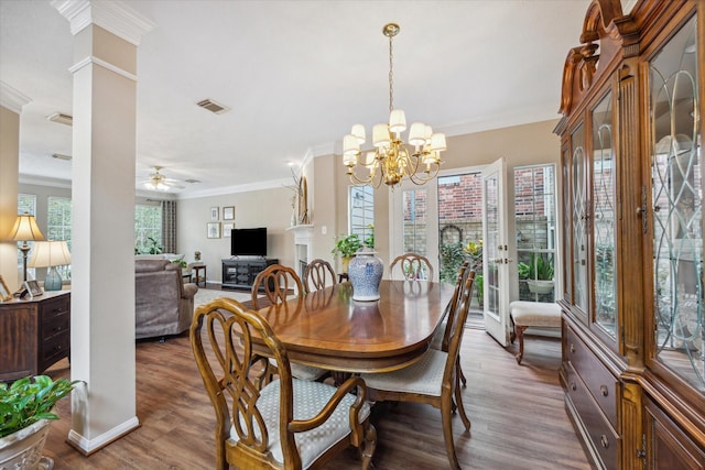 dining room featuring crown molding, wood-type flooring, and ceiling fan with notable chandelier