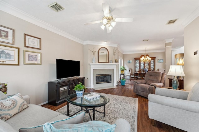 living room with ceiling fan with notable chandelier, dark hardwood / wood-style floors, and ornamental molding