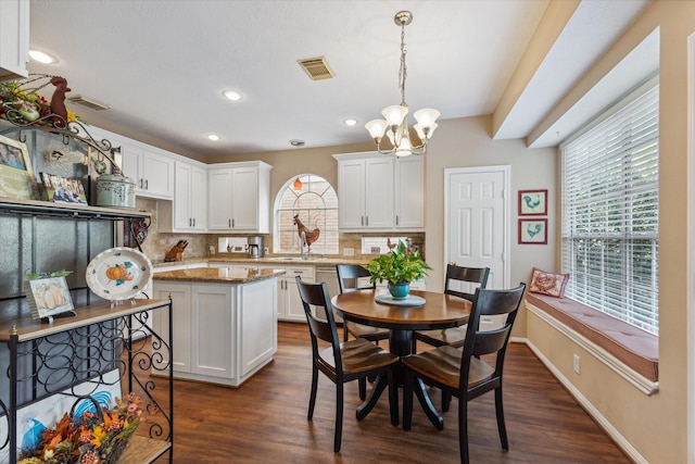 dining space featuring a notable chandelier and dark hardwood / wood-style floors