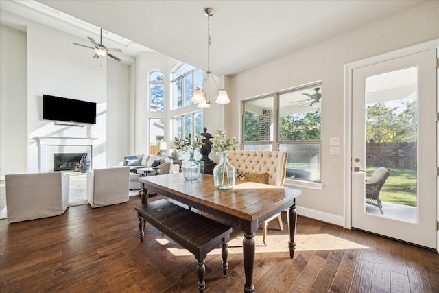 dining area with ceiling fan with notable chandelier and dark hardwood / wood-style flooring