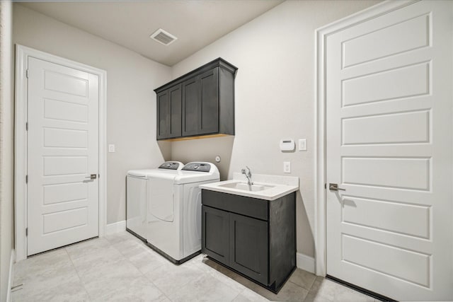 laundry room with cabinets, light tile patterned floors, sink, and washing machine and dryer