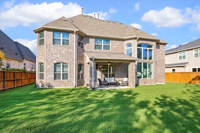 back of house featuring a lawn and a patio