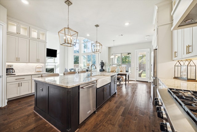 kitchen featuring white cabinetry, sink, stainless steel appliances, an island with sink, and pendant lighting