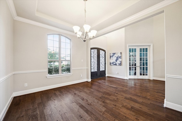 foyer entrance with french doors, dark hardwood / wood-style flooring, a tray ceiling, and an inviting chandelier