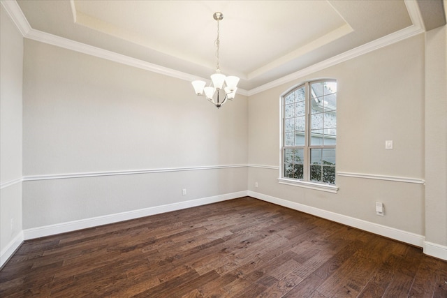 spare room featuring dark hardwood / wood-style floors, crown molding, a chandelier, and a tray ceiling