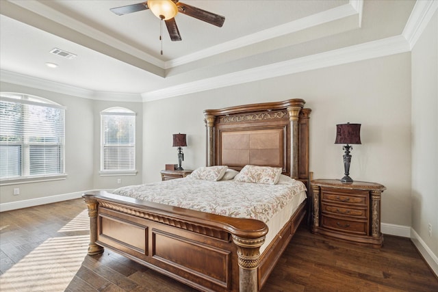 bedroom featuring dark hardwood / wood-style flooring, a raised ceiling, ceiling fan, and crown molding