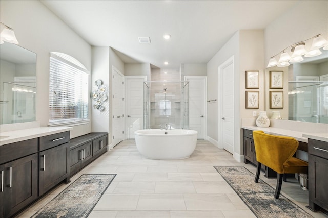 bathroom with vanity and shower with separate bathtub