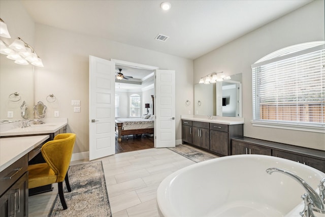 bathroom with ceiling fan, a bathtub, and vanity