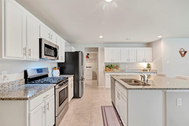 kitchen with white cabinetry, sink, light tile patterned floors, and appliances with stainless steel finishes