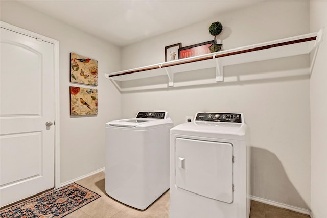 laundry room with independent washer and dryer and light tile patterned floors