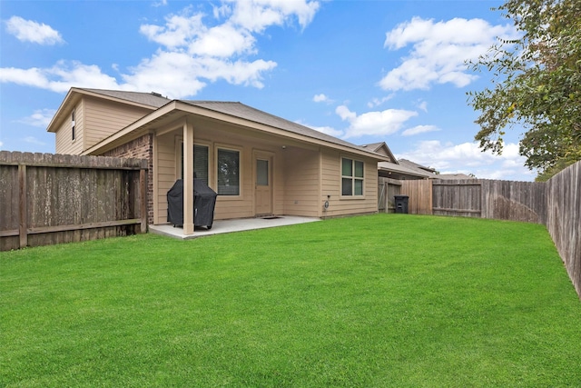 rear view of house with a lawn and a patio