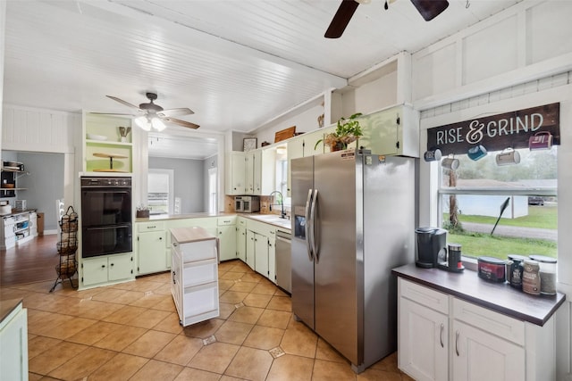 kitchen featuring white cabinets, plenty of natural light, light tile patterned floors, and stainless steel appliances