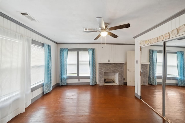 unfurnished living room featuring a brick fireplace, a wealth of natural light, ceiling fan, and ornamental molding