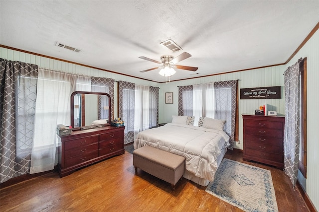 bedroom featuring hardwood / wood-style floors, a textured ceiling, ceiling fan, and crown molding