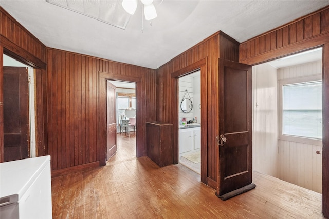 corridor featuring hardwood / wood-style floors, sink, and wood walls