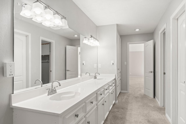 full bath with carpet floors, a sink, baseboards, and double vanity