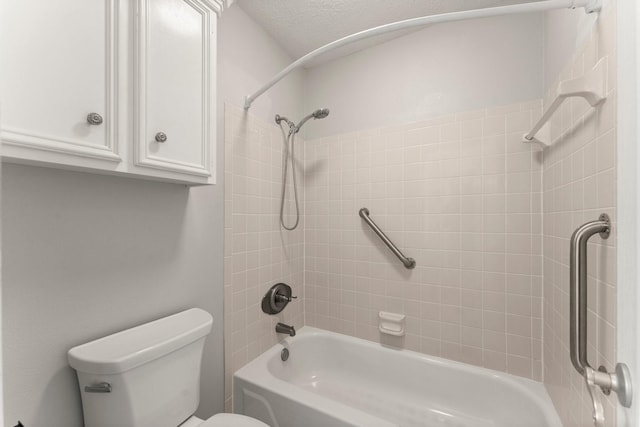 bathroom featuring tiled shower / bath combo and toilet