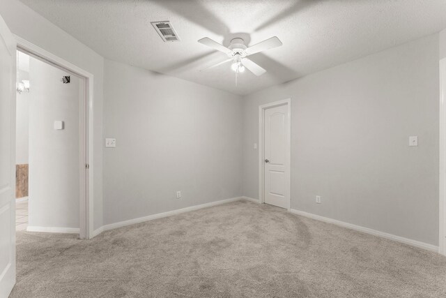 carpeted spare room with ceiling fan and a textured ceiling