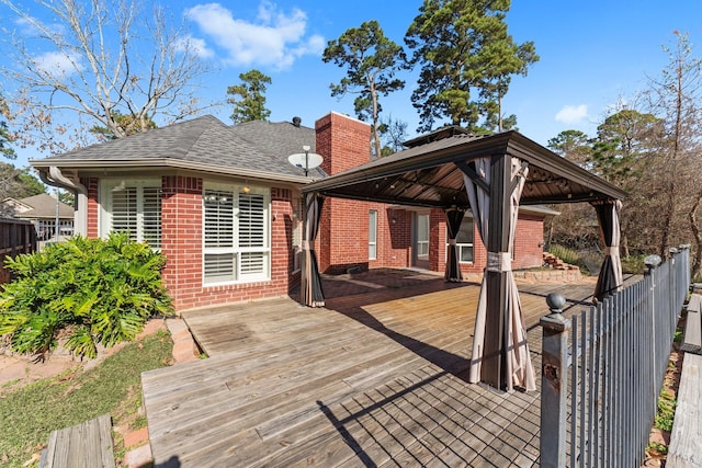 wooden deck featuring fence and a gazebo