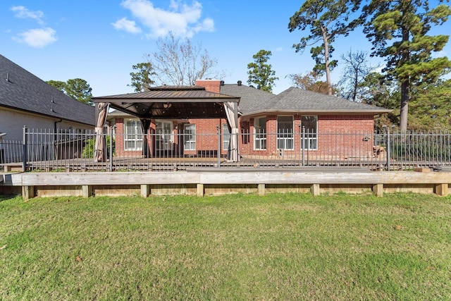 back of house featuring a gazebo, a lawn, and a deck