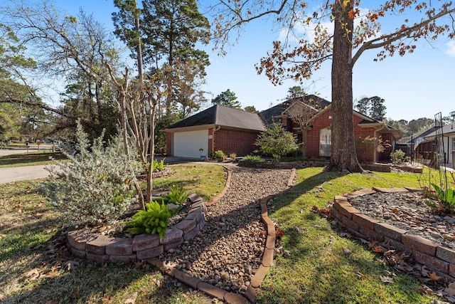 view of front facade featuring a garage, brick siding, and a front yard