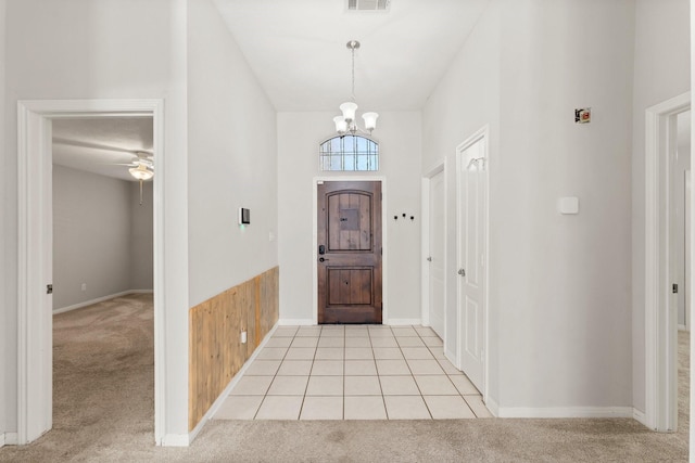 carpeted foyer with ceiling fan with notable chandelier