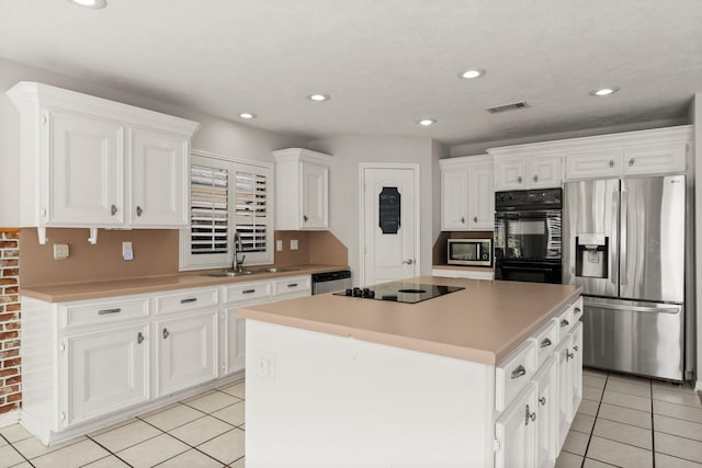 kitchen featuring sink, a center island, white cabinetry, and black appliances