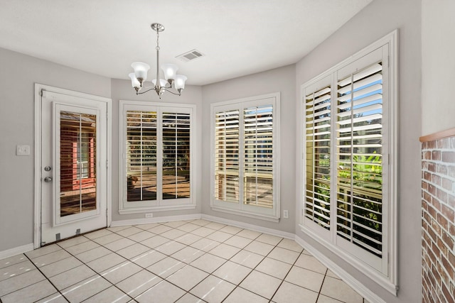 unfurnished dining area with a chandelier, light tile patterned floors, visible vents, and baseboards