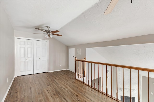 bonus room featuring hardwood / wood-style floors, ceiling fan, and lofted ceiling