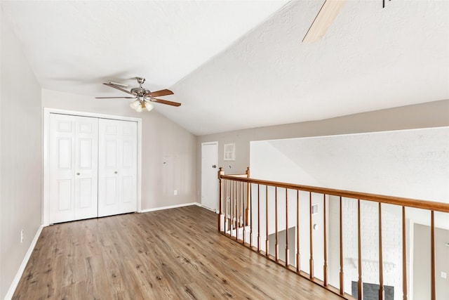 additional living space with ceiling fan, lofted ceiling, light hardwood / wood-style floors, and a textured ceiling