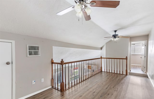 bonus room featuring wood-type flooring, plenty of natural light, ceiling fan, and a textured ceiling