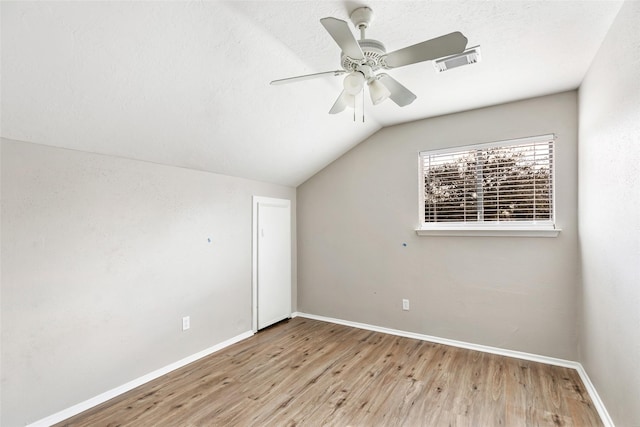 additional living space with ceiling fan, vaulted ceiling, a textured ceiling, and light wood-type flooring