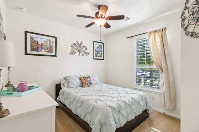 bedroom with ceiling fan and light carpet