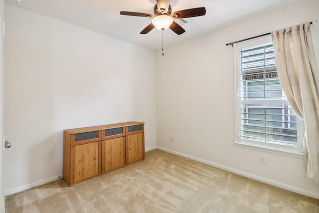 unfurnished room with ceiling fan and light colored carpet