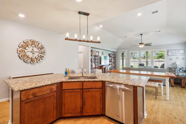 kitchen with stainless steel dishwasher, ceiling fan with notable chandelier, sink, and an island with sink