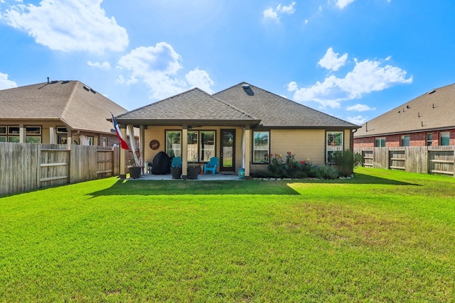 rear view of house featuring a lawn and a patio