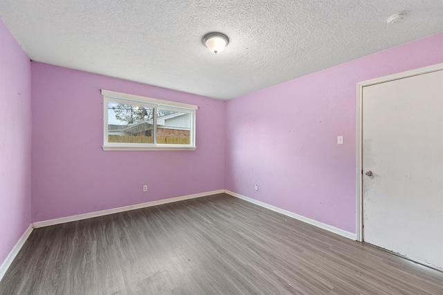 spare room with hardwood / wood-style floors and a textured ceiling