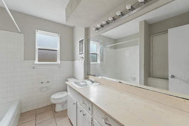 full bathroom with tile patterned floors, vanity, tile walls, washtub / shower combination, and toilet