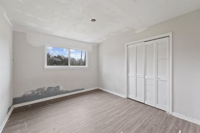 unfurnished bedroom featuring a closet and hardwood / wood-style flooring