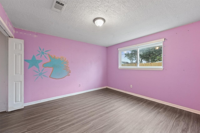 empty room featuring dark wood-type flooring and a textured ceiling