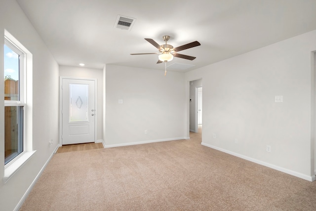 spare room with ceiling fan and light colored carpet