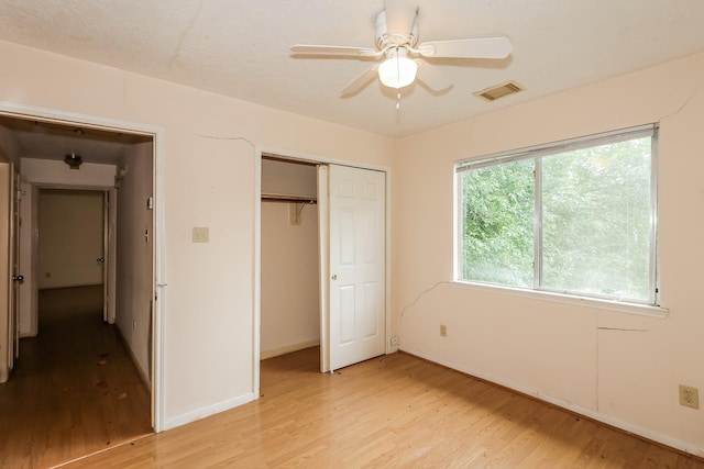 unfurnished bedroom featuring a closet, light hardwood / wood-style flooring, and ceiling fan