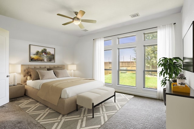 bedroom with multiple windows, light colored carpet, and ceiling fan