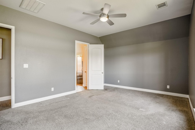 unfurnished bedroom with ceiling fan, light colored carpet, ensuite bathroom, and vaulted ceiling