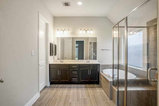 bathroom featuring vanity, lofted ceiling, and shower with separate bathtub