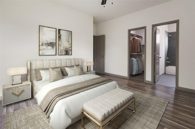 bedroom with dark wood-type flooring, ensuite bathroom, a walk in closet, ceiling fan, and a closet