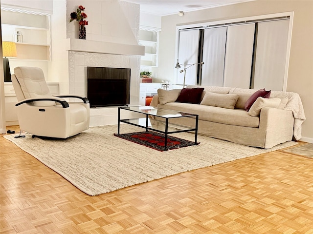 living room with a tiled fireplace and light parquet floors