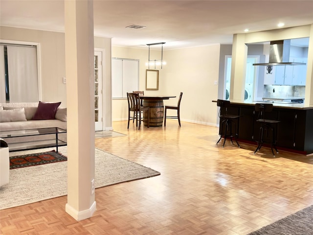 living room featuring ornamental molding, parquet floors, visible vents, and baseboards