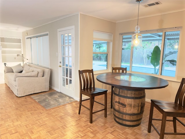 dining space with ornamental molding, plenty of natural light, visible vents, and baseboards